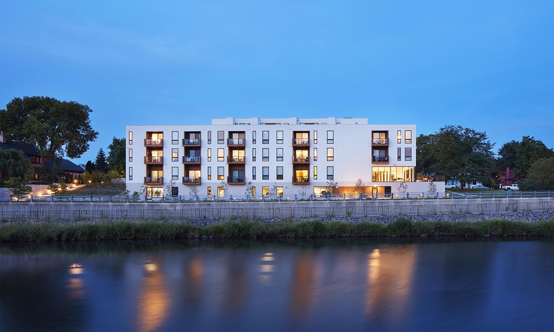 Lofts at Mayo Park exterior with lights reflecting in water